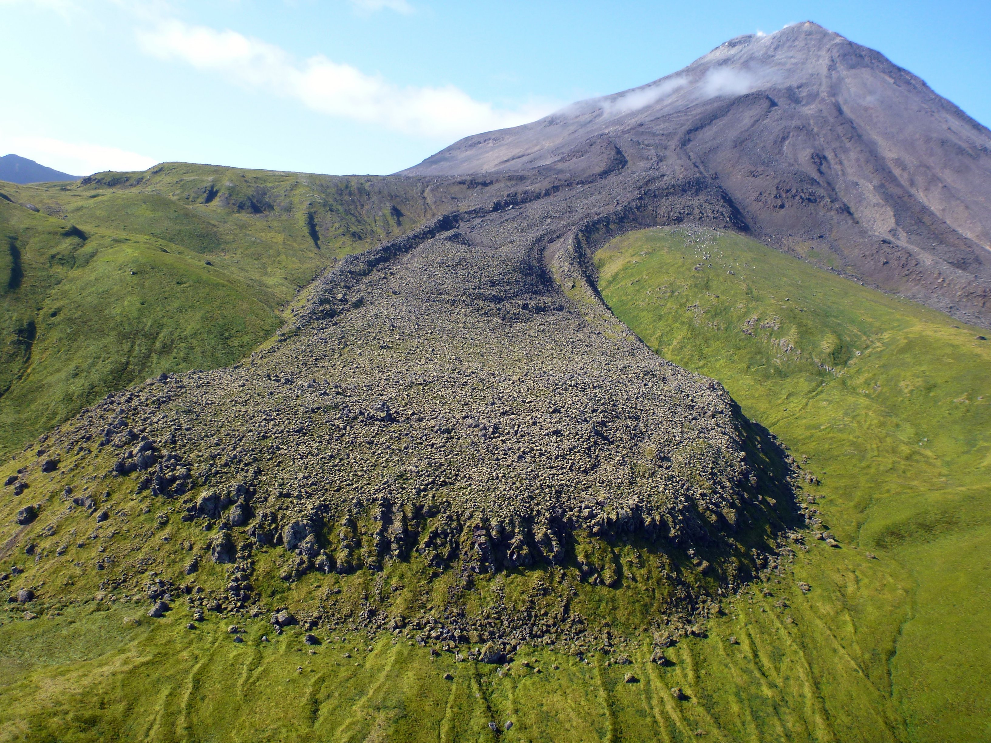 Kanaga Volcano, Aleutian Islands, as seen from the east. The blocky andesite lava flow in the foreground erupted in 1906. Photo credit: Michelle Coombs, USGS